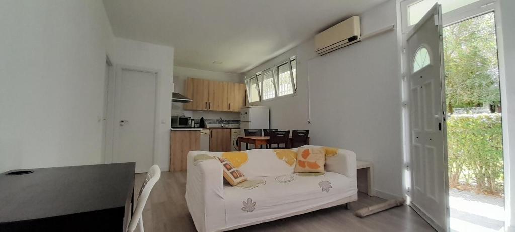 sala de estar con sofá blanco y mesa en El Colmenar Apartamento, en Madrid