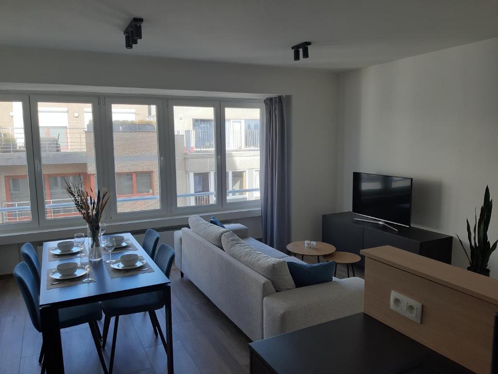 a living room with a couch and a table at Novia - Op de zeedijk, parkeren mogelijk in Ostend