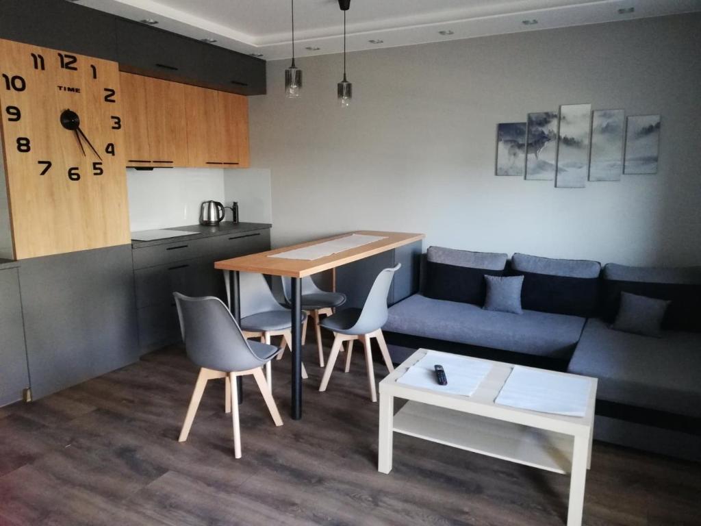 uma sala de estar com um sofá e uma mesa em Apartament Shadow em Bialystok