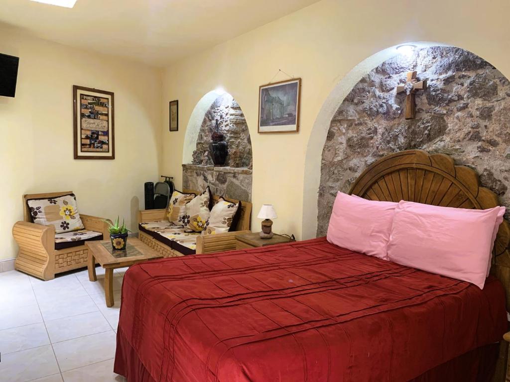 Un dormitorio con una cama y una pared de piedra. en La Capilla Apartment In ExHacienda La Escalera, en Guanajuato