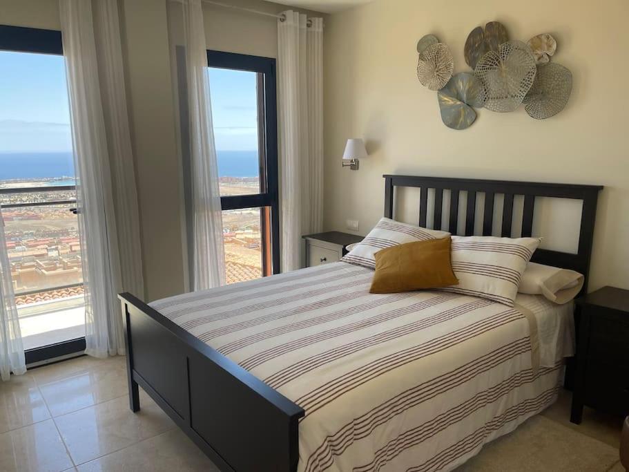 a bedroom with a bed with a view of the ocean at Vivienda adosada en Castillo, Caleta de Fuste in Caleta De Fuste