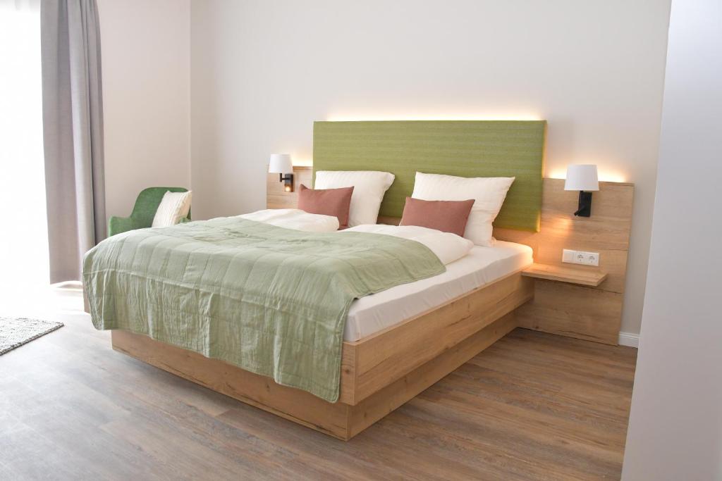 um quarto com uma cama com uma cabeceira verde em Landhaus Hamester - Hotel & Restaurant - neu eröffnet September 2022 em Basthorst