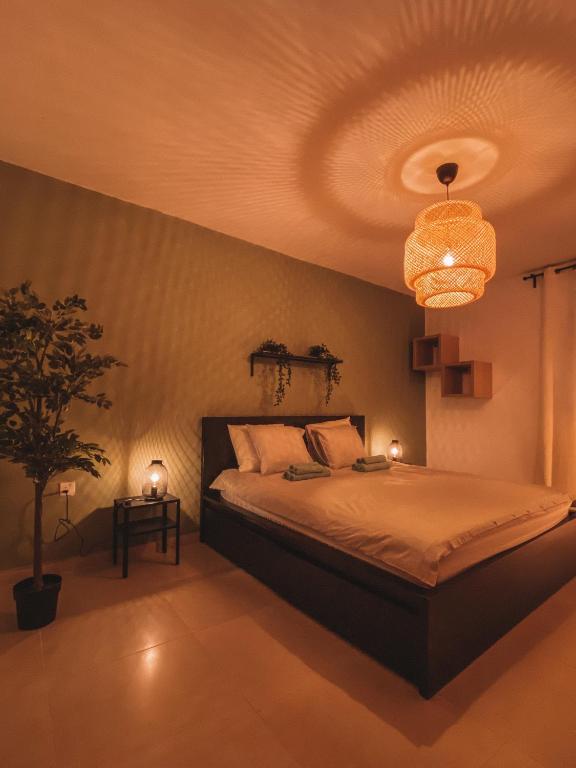 a bedroom with a large bed and a chandelier at Exclusive Paceville NEW 3 bedrooms apartment in St. Julianʼs