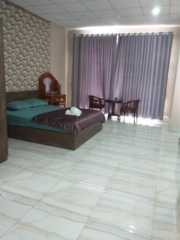 a bedroom with a bed and a table and chairs at Hello Hotel in Bùi Tiếng