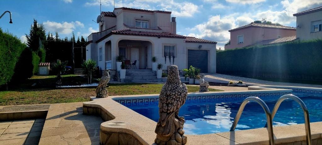 uma casa com piscina em frente a uma casa em Villa Rosa de los Vientos em Les tres Cales