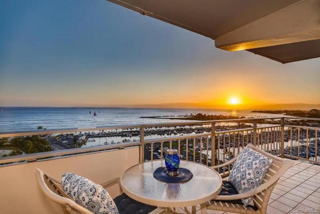 a balcony with a table and chairs and the ocean at Ilikai #1743 Panoramic views on Waikiki Beach in Honolulu