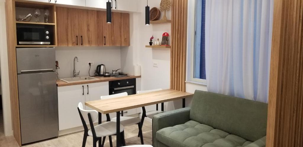 a small kitchen with a table and a green couch at 2A New Bazaar Apartment in Tirana