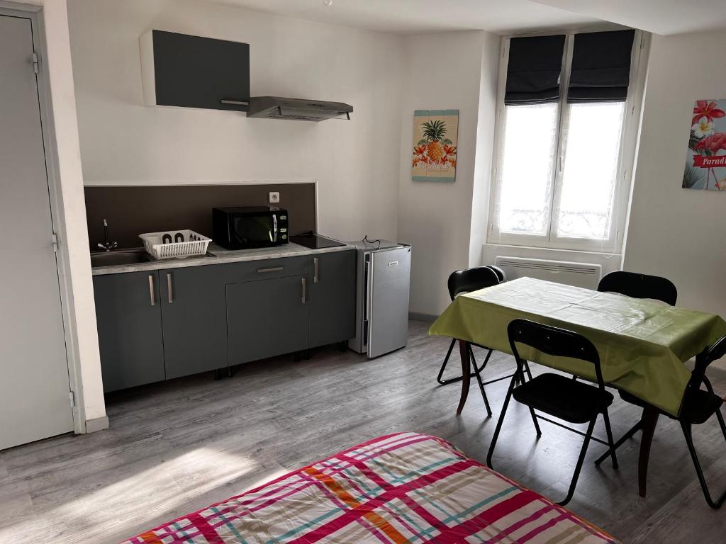 a kitchen with a table and chairs in a room at F2 gatinais in Pithiviers