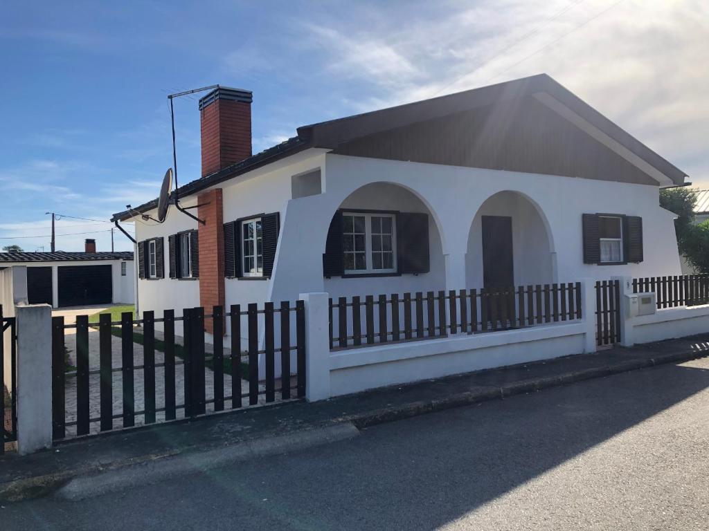 a white house with a fence in front of it at Buztinzuri Da Ria in Torreira