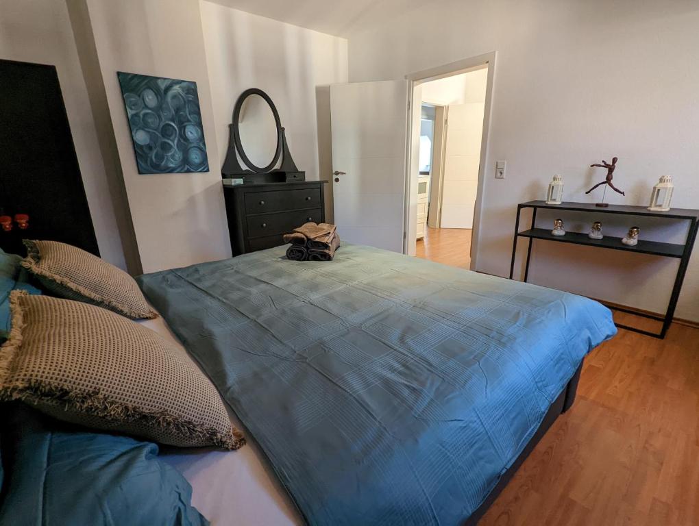 a bedroom with a bed with a blue comforter at Schönes 2 Zimmer Appartment in der Altstadt von Koblenz in Koblenz