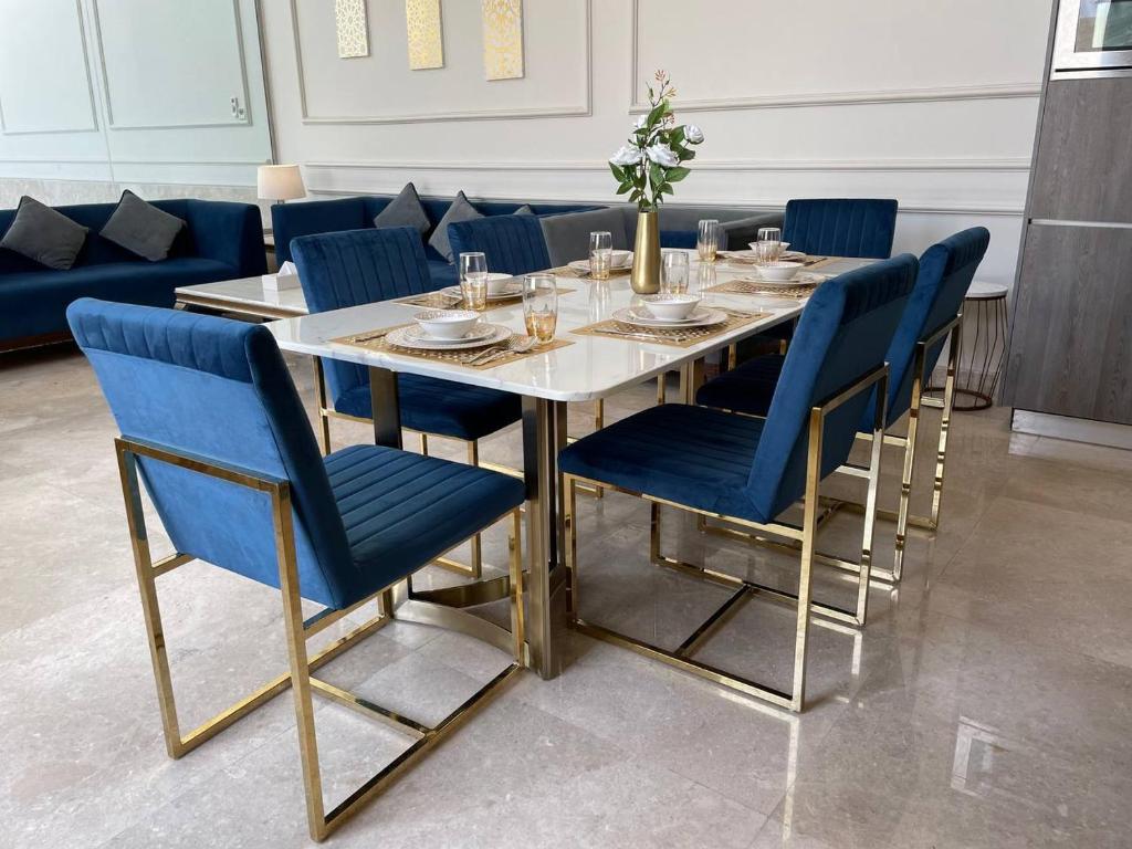 a dining room with a table and blue chairs at شاليه المنى - الخبر - للعائلات in Al Khobar