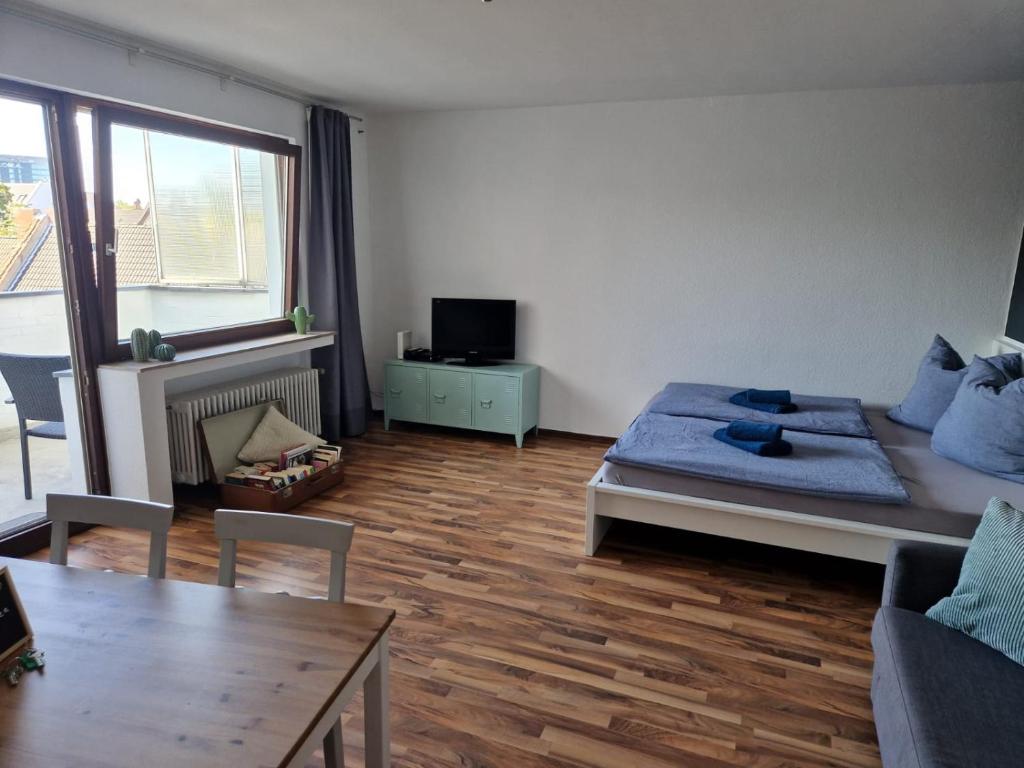 Hotel Well located flat with balcony, a living room with a bed and a table at Well located flat with balcony in Düsseldorf
