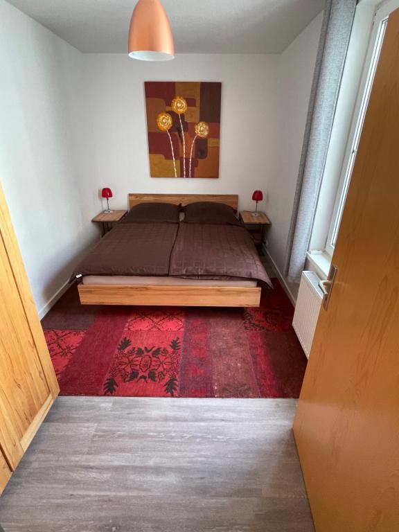 a bedroom with a bed and a red rug at Ruhige Ferienwohnung in Rostock