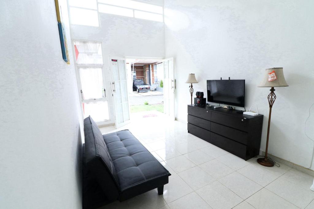 sala de estar con sofá y TV en Villa Casa Blanca by Masterpiece Villa, en Batu