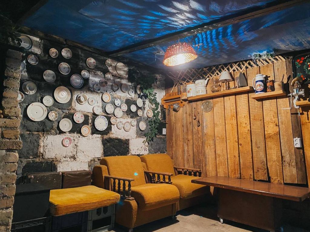 Habitación con mesa, sillas y platos en la pared en Unoyan Guest House en Gyumri
