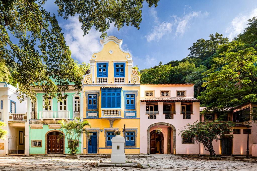 une maison colorée avec des fenêtres bleues et une tour dans l'établissement JO&JOE Rio de Janeiro Largo do Boticario, à Rio de Janeiro