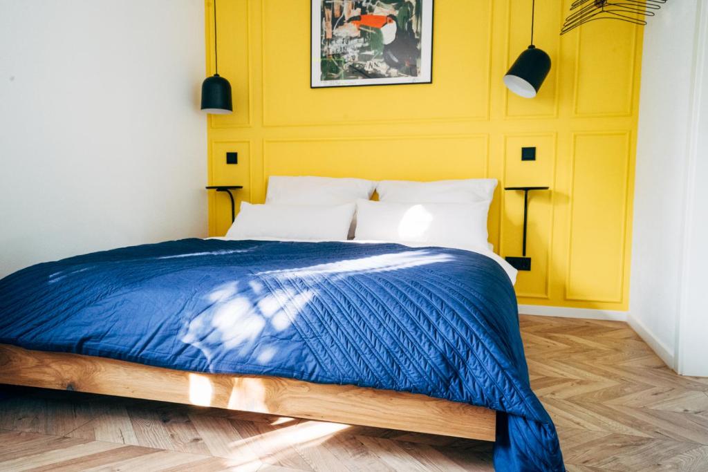 1 dormitorio con cama azul y pared amarilla en Wunderschönes Chalet mit Gästehaus in der Natur + Pferdeweide, en Sangerhausen