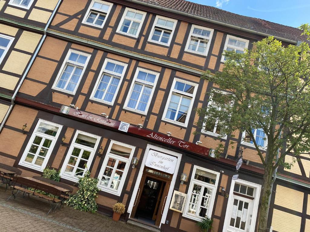 a building on a street with a bench in front of it at Altenceller Tor, Hotel & Restaurant in Celle