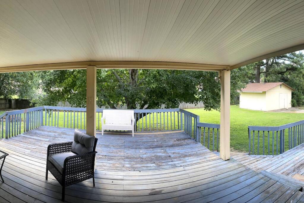 a covered deck with a chair and a grill at Cozy & spacious 4 bed home with indoor fire place in Madison