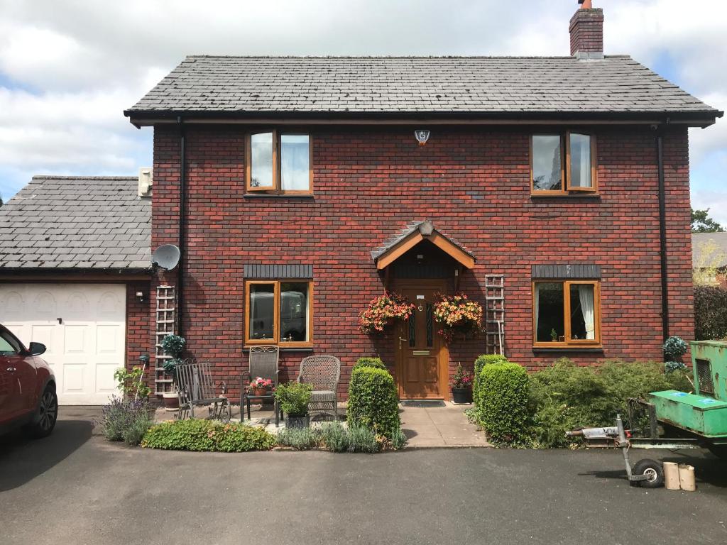 a red brick house with a white garage at Roselea in Glasbury