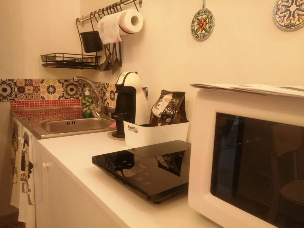 encimera de cocina con microondas y fregadero en Va' Nedda, en Lentini