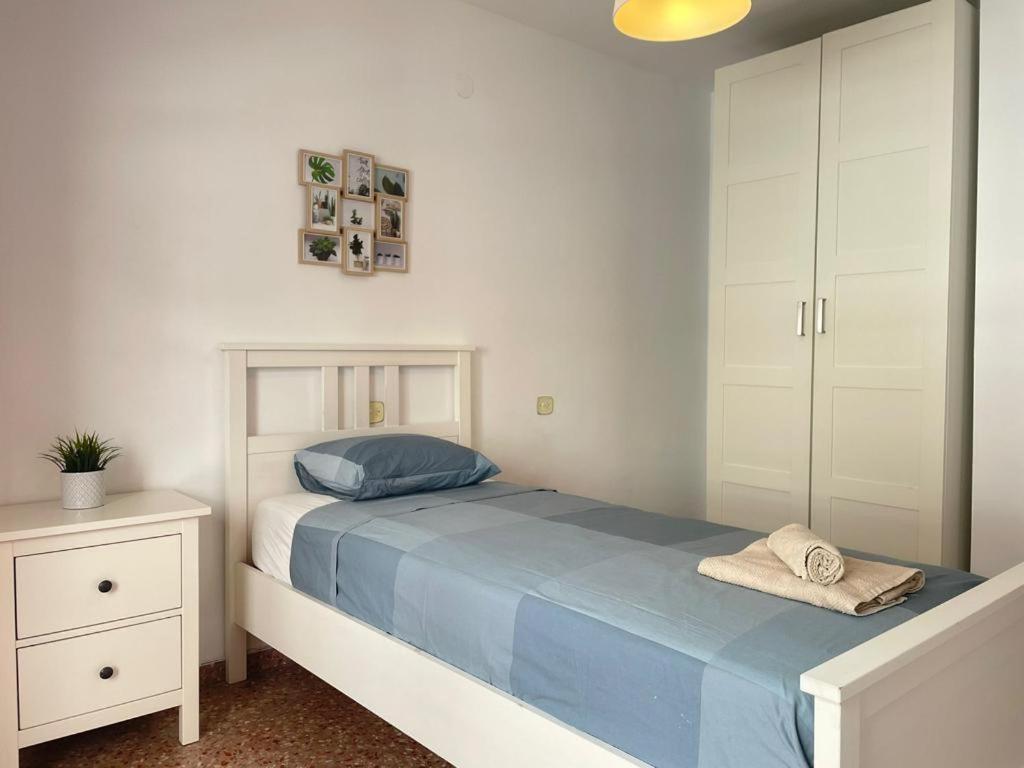 een slaapkamer met een bed met blauwe lakens en een spiegel bij UIM Mediterraneo Isabel 23 Wifi in Puerto de Sagunto