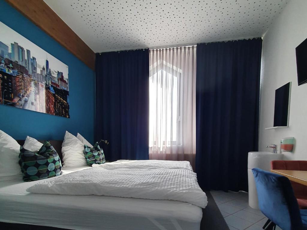 a bedroom with blue walls and a bed and a window at Argenta Living 131 in Künzell