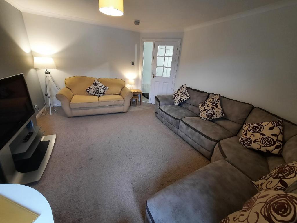 Sala de estar con 2 sofás y TV en Ardfern Apartments en Airdrie