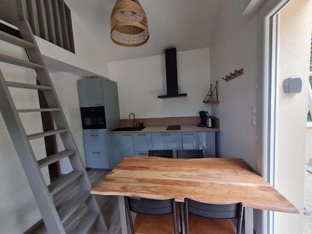 a kitchen with a wooden table and some chairs at "les ecureuils"Logement indépendant climatisé in Veigné