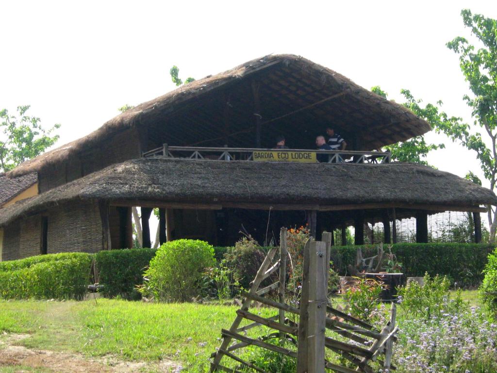 a hut with two people sitting on a balcony at Bardia Eco Lodge in Bardiyā