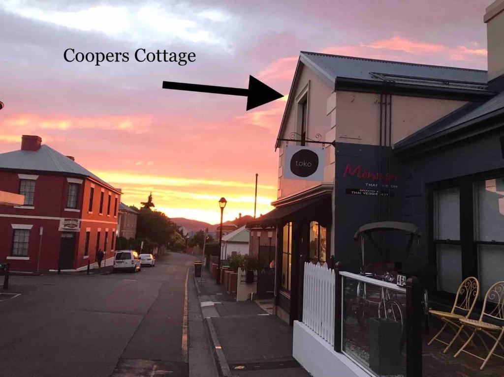 a view of a street at sunset with the wordscoopers cottage at Coopers Cottage Battery Point in Hobart