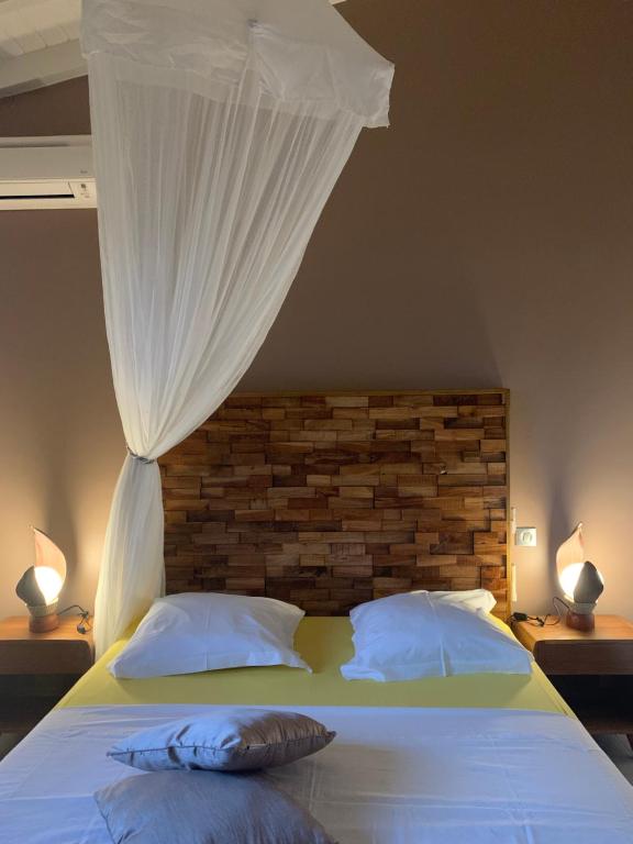um quarto com uma cama com uma cortina por cima em Chez BIBI em Grand-Bourg