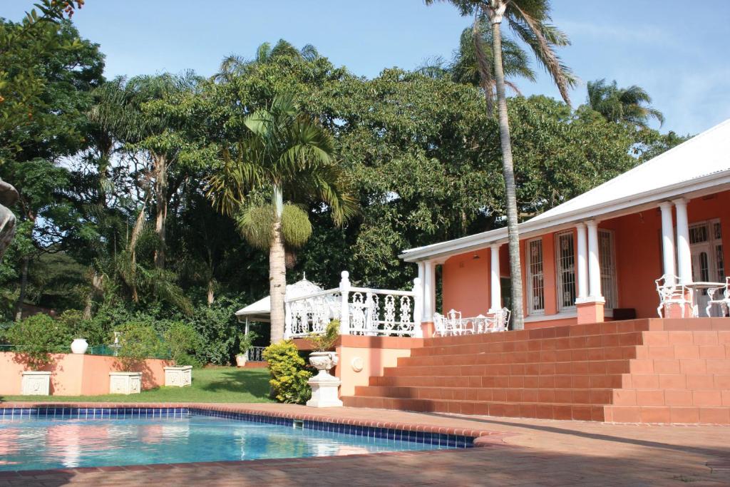 a house with a swimming pool in front of a house at Sica's Guest House in Durban