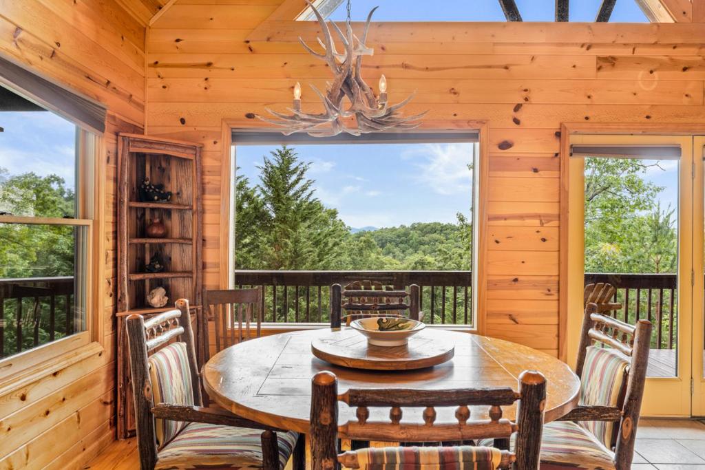 uma sala de jantar com uma mesa e cadeiras num camarote em Large Cabin with views of Beautiful NC Mountains em Murphy