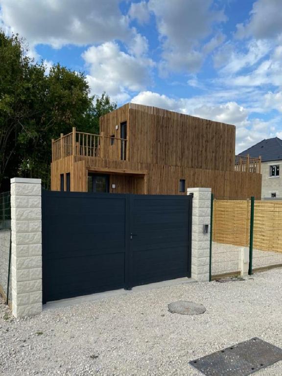 a fence with a blue gate in front of a building at Duplex atypique en bois entre ville et verdures in La Chapelle-Saint-Mesmin