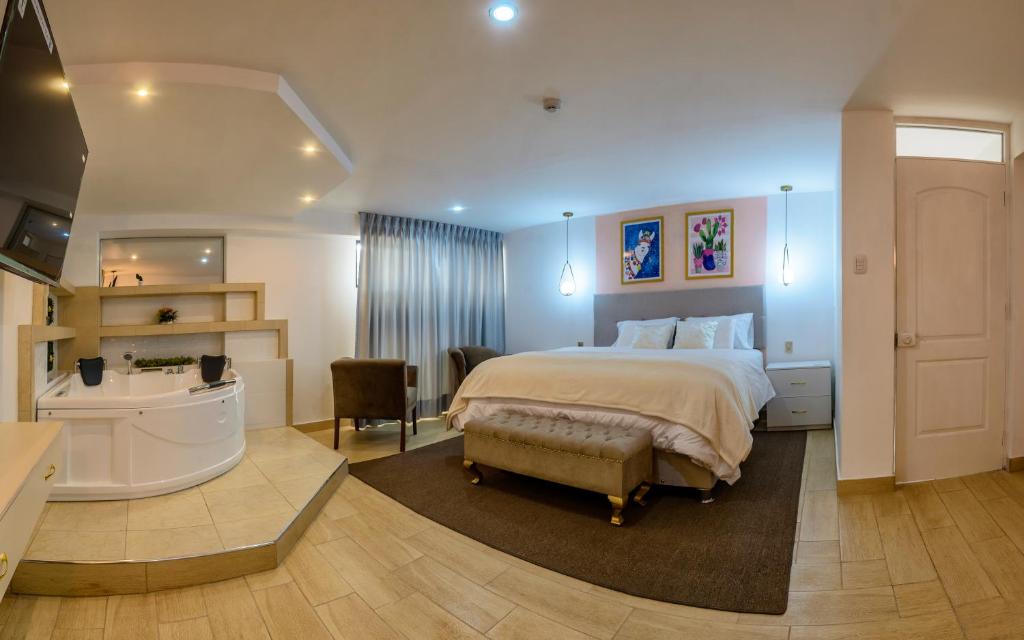 1 dormitorio con 1 cama grande y baño en Hotel Huaytapallana suites, en Huancayo