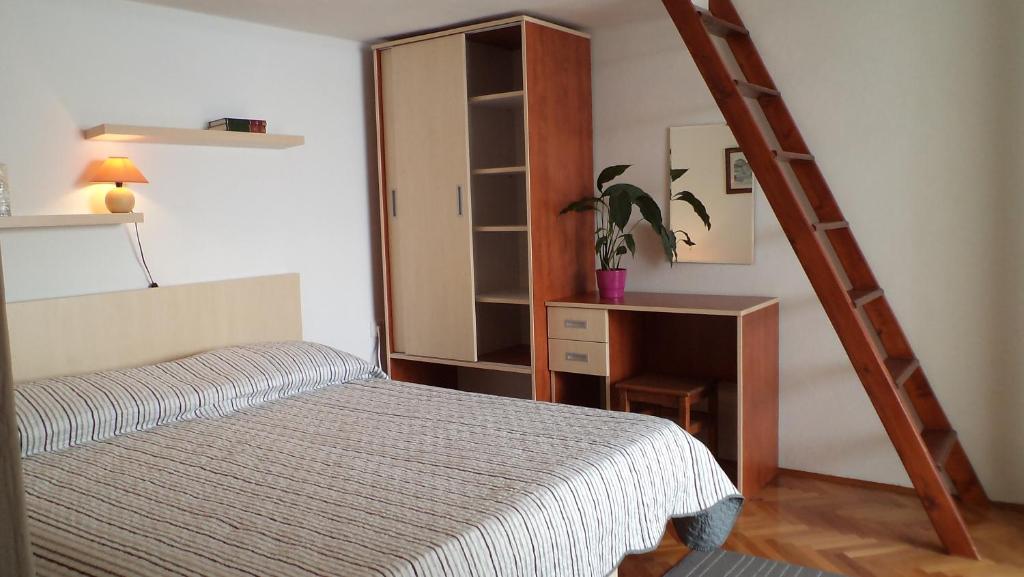 sypialnia z łóżkiem i drewnianą drabiną w obiekcie Apartments by the sea Igrane, Makarska - 5266 w mieście Igrane