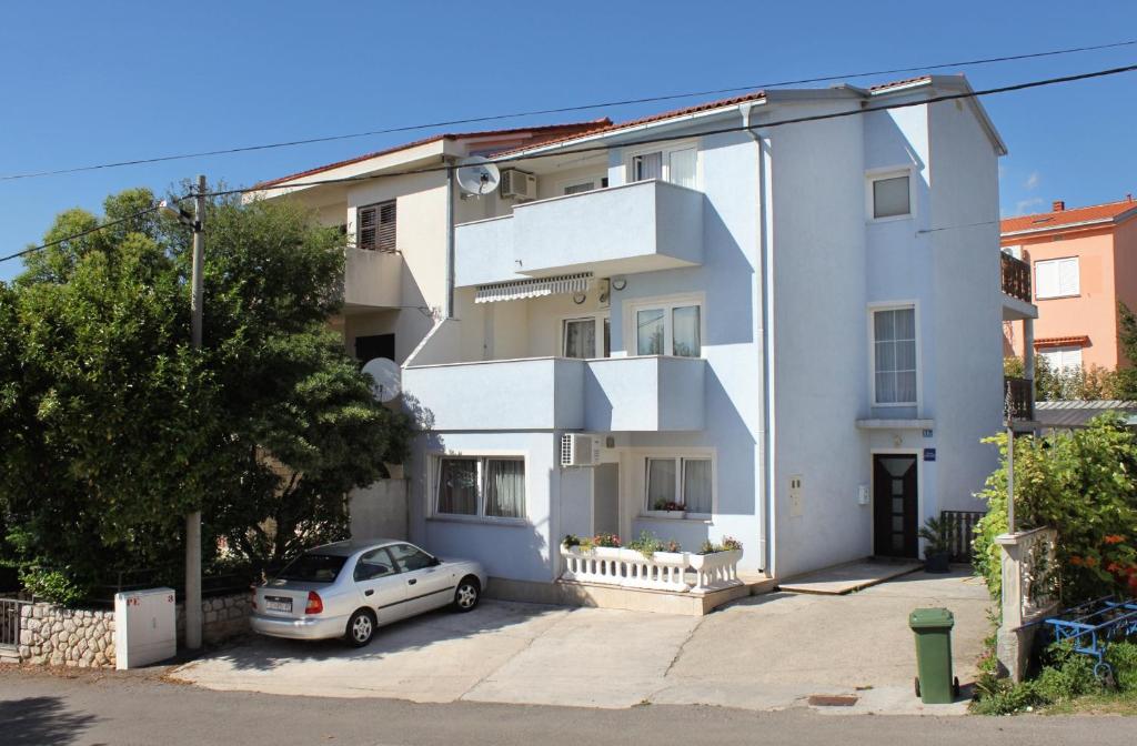 a white house with a car parked in front of it at Apartments with a parking space Jadranovo, Crikvenica - 5285 in Jadranovo