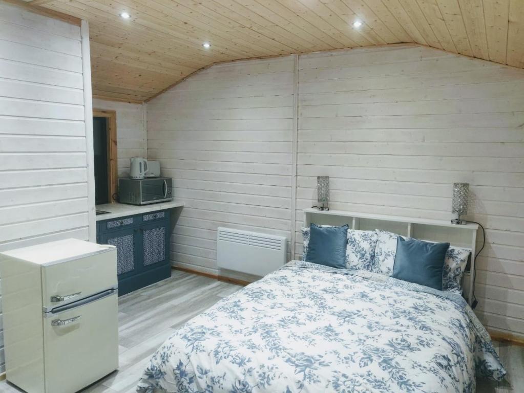 a bedroom with a bed and a kitchen in it at Cosy log cabin with views of Scrabo tower in Comber