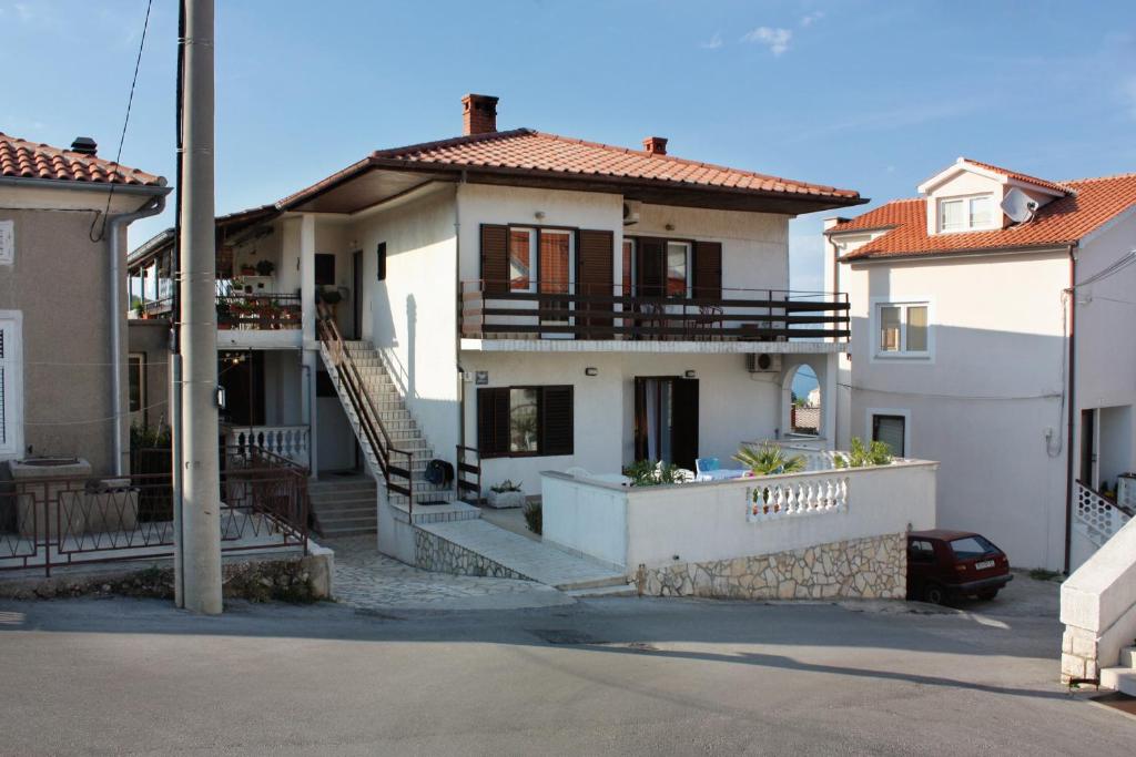 uma casa branca com uma escada em frente em Double Room Vrbnik 5301b em Vrbnik