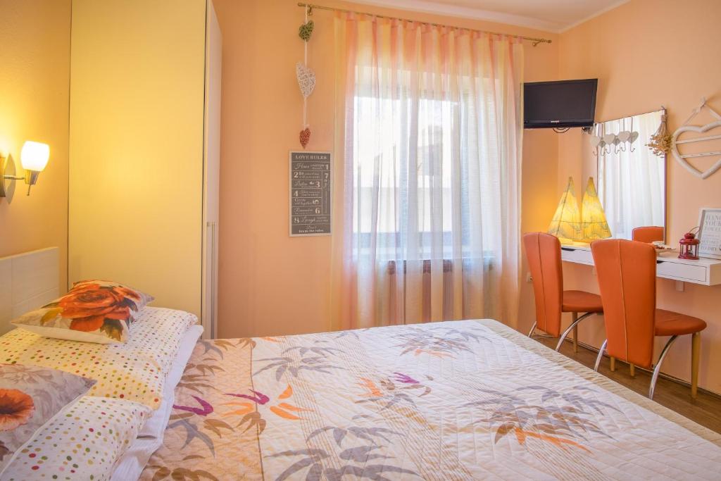 een slaapkamer met een bed, een tafel en een bureau bij Double Room Vrbnik 5302b in Vrbnik
