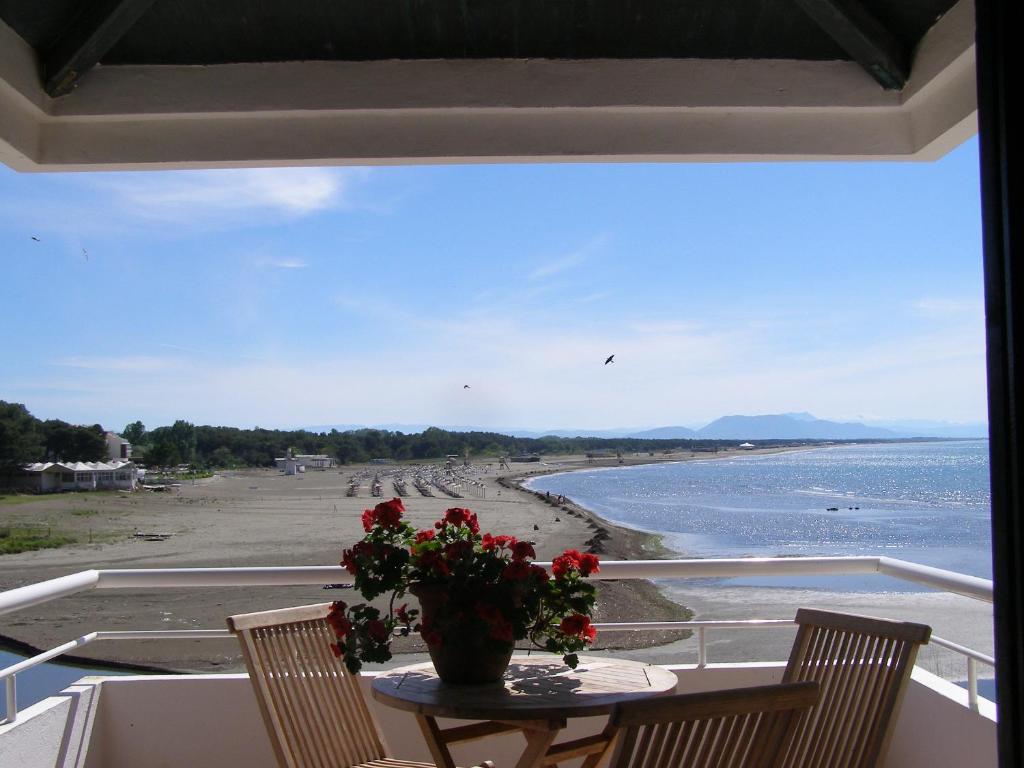 a table with a vase of flowers on the beach at Palastura Apartments in Ulcinj