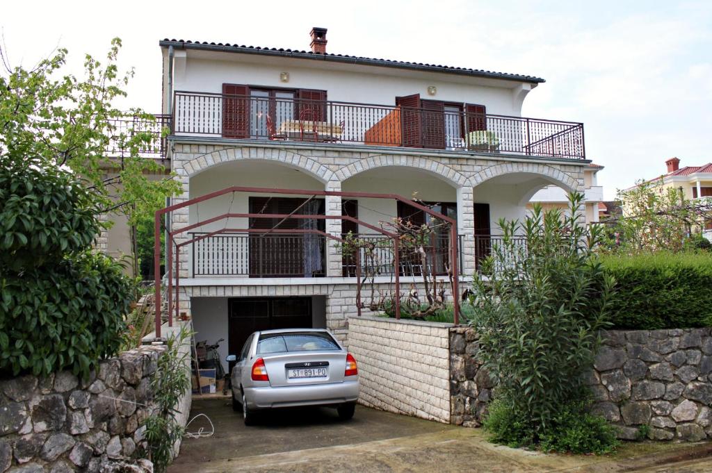 un coche aparcado frente a una casa en Apartment Malinska 5284a en Malinska