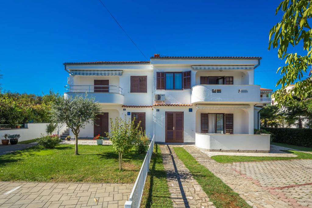 a white house with a pathway in front of it at Apartments with a parking space Vantacici, Krk - 5313 in Malinska