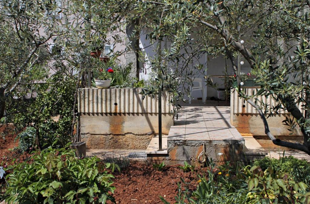a garden with a wooden fence with a flower pot on it at Double Room Krk 5294b in Krk