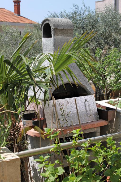 a stone oven in a garden with plants at Double Room Krk 5294b in Krk