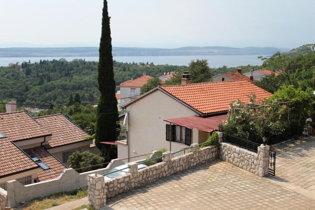 a house with a stone fence in a village at Apartments by the sea Dramalj, Crikvenica - 5522 in Dramalj