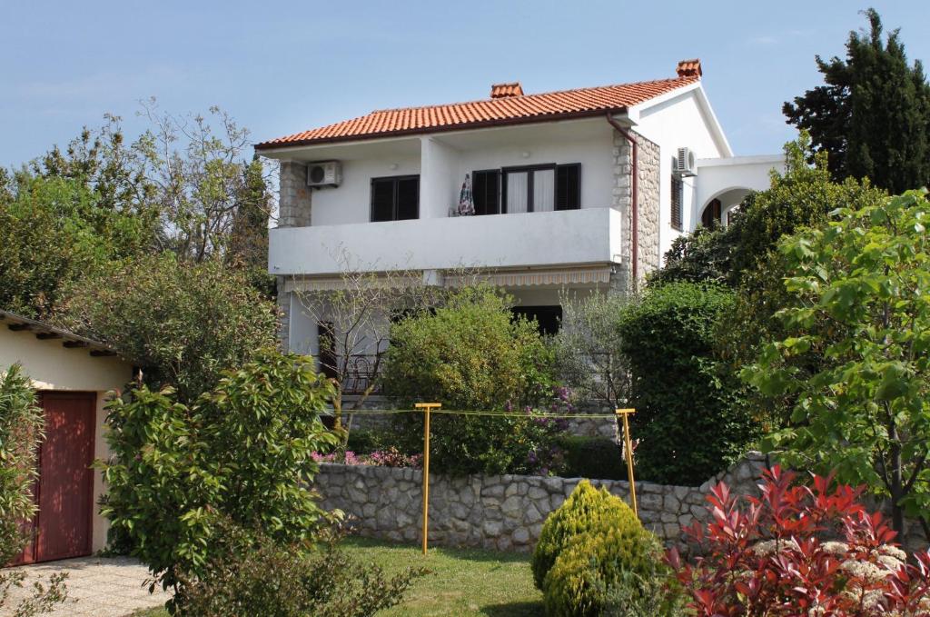 a house with a stone fence in front of it at Apartment Krk 5318a in Krk