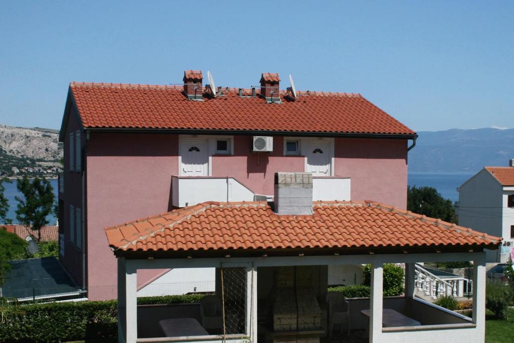 a house with a red roof with a porch at Studio Baska 5450b in Baška