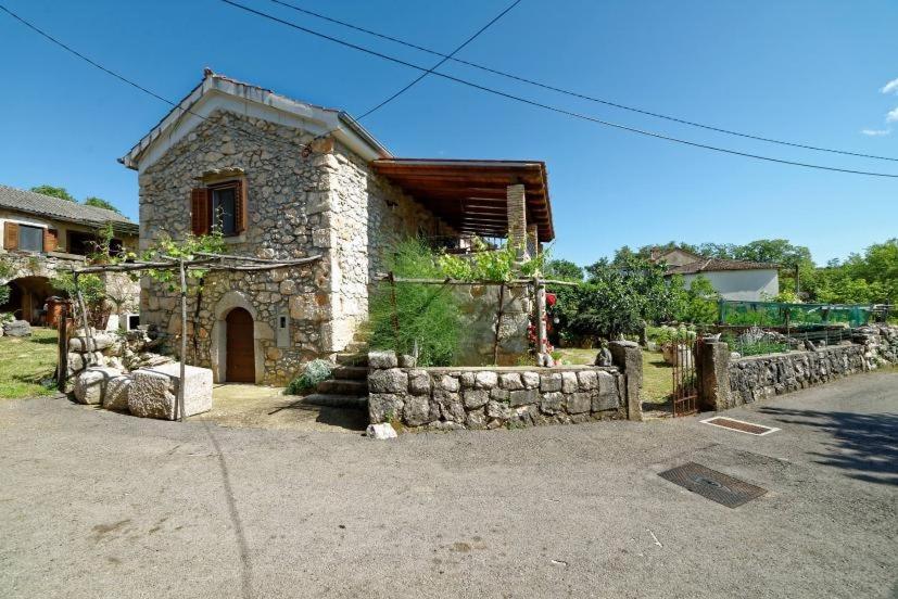 a small stone house with a stone wall at Apartments with a parking space Zupanje, Krk - 5307 in Županje